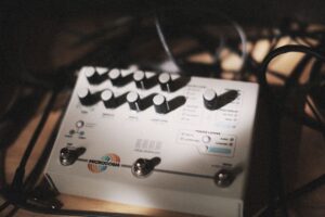 Close-up of audio effects pedal surrounded by cables in a music studio
